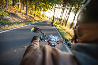 Zwei Motorradfahrer auf einer Landstraße. 